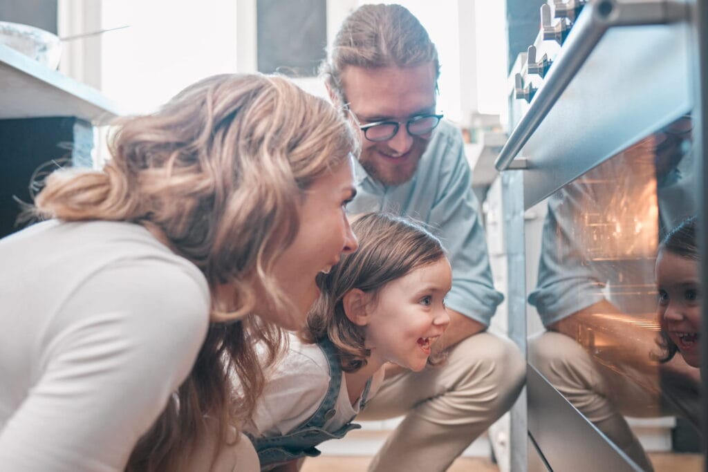 family-baking-together-in-kitchen-with-stainless steel oven